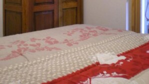 Ein Schlafzimmer mit einem Bett, einem Holzschrank und einer Tür.