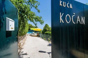 Welcome to KUČA KOČAN, where a beautifully manicured entrance sets the tone for a serene stay.