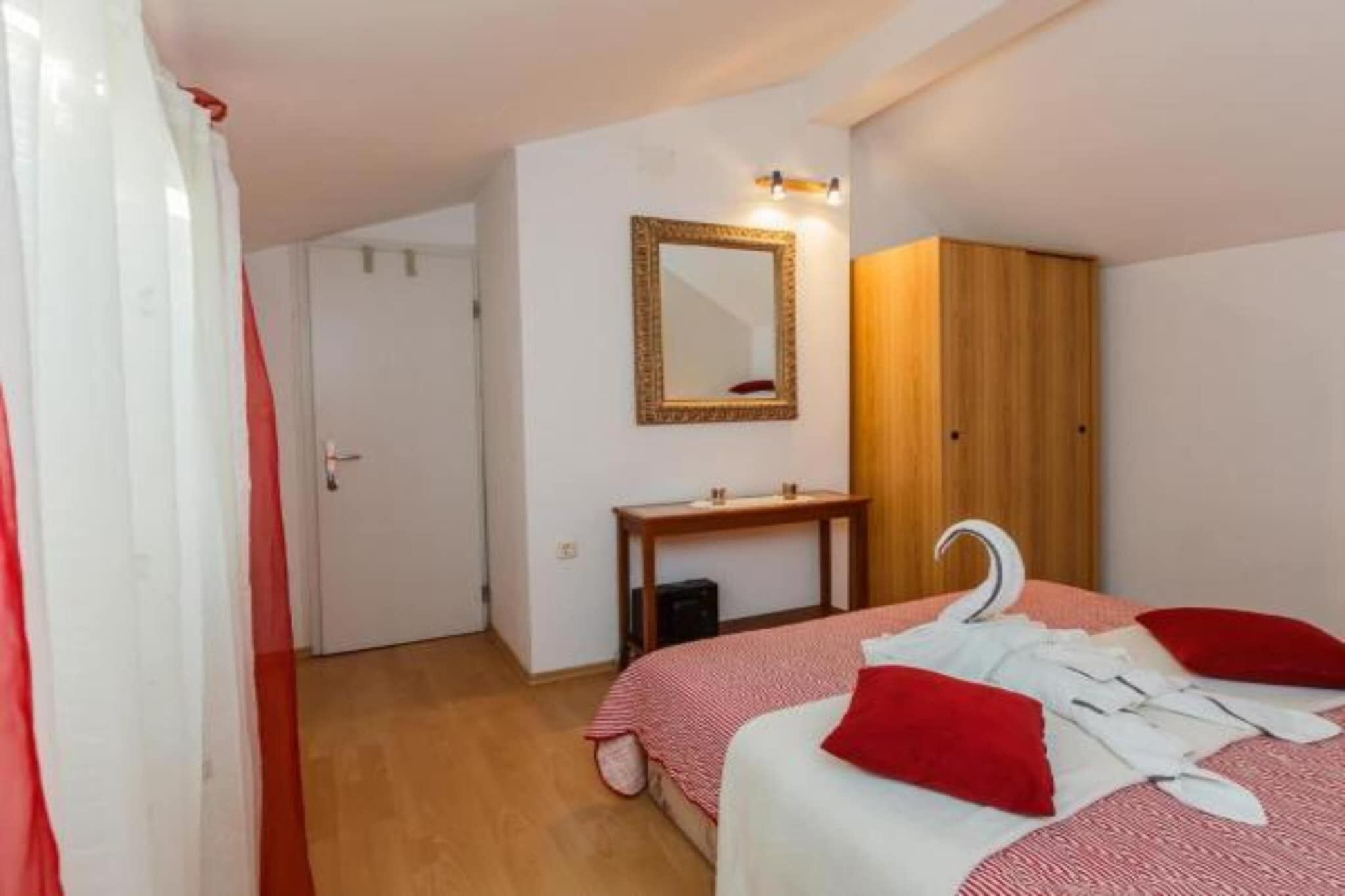 Une chambre à coucher avec un lit, une armoire en bois, un miroir et une table de chevet.