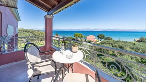 A balcony with a table, chairs, and a view of the sea and mountains. - Studio Apartment '8' with Sea View, Wi-Fi and Air Conditioning (Corfu)