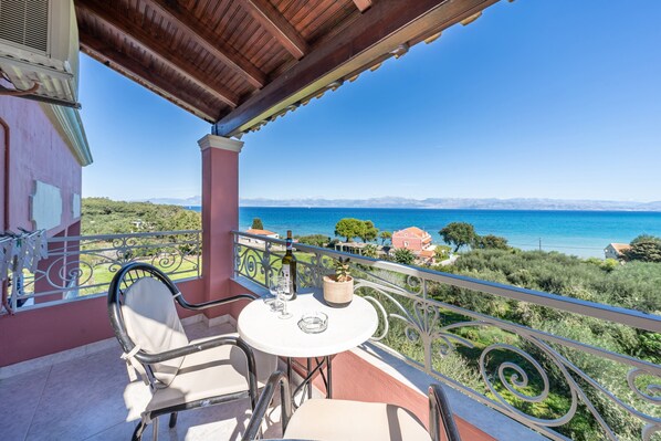 A balcony with a table, chairs, and a view of the sea and mountains. - Studio Apartment '8' with Sea View, Wi-Fi and Air Conditioning (Corfu)