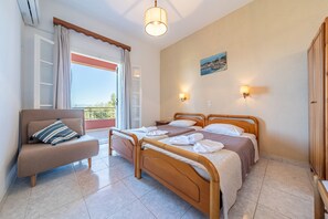 Un dormitorio con dos camas, un sofá, un balcón y un cuadro en la pared.