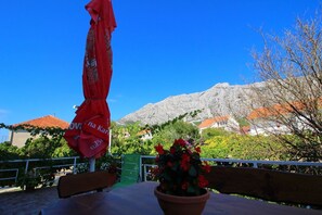 Relax in a scenic outdoor space with a mountain view, surrounded by a potted plant and a shaded area.