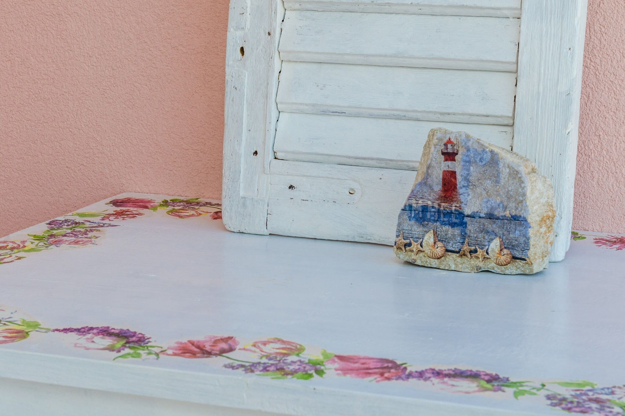 A decorative piece with a lighthouse on a floral table.