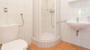A bathroom with a shower, toilet, and sink.
