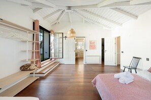 Un dormitorio amplio con una cama grande, un banco de madera y una silla.