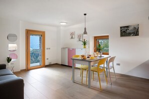 A modern kitchen with a dining area, a large window, and a view of the outdoors.