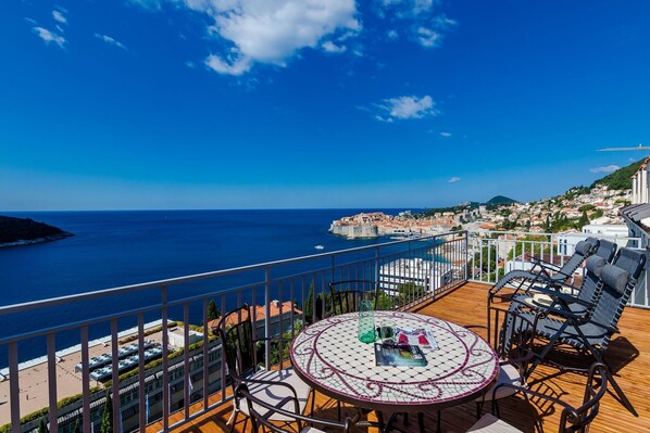 Ein Balkon mit Blick auf das Meer und eine Küstenstadt.