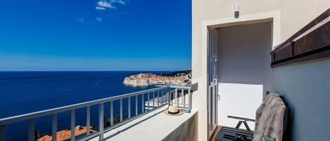 Ein Balkon mit Blick auf das Meer und eine Stadt.