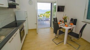 Una cocina con comedor, vistas al exterior y un reloj en la pared.