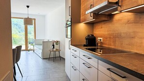 Eine moderne Küche mit Holzschränken, einem eingebauten Herd und einer Kaffeemaschine.
