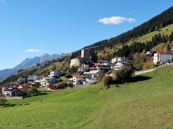 A hillside village with traditional houses, a castle, and a mountain backdrop. - Beautiful apartment for 4 people with WIFI, TV and terrace (Urgen)
