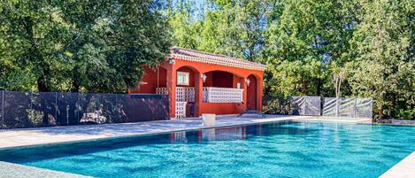 A swimming pool with a red building in the background.