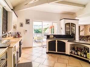 Enjoy family meals and gatherings in this spacious kitchen and dining area, featuring a central island, oven, and sliding glass door to the outdoor patio.