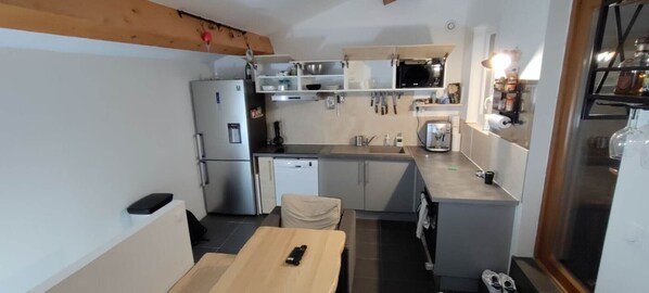 A compact kitchen with a refrigerator, microwave, and sink.