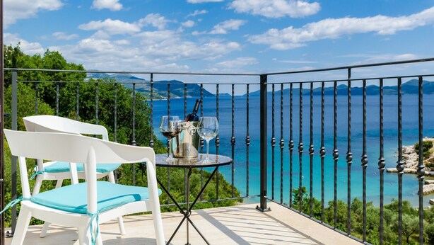 A balcony with a table set for two, overlooking a scenic coastal view with mountains in the distance. - Quiet SeaView Villa Dubrovnik Region - Three Bedroom Villa with Terrace and Swimming Pool (Zaton Doli)