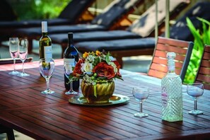 Enjoy a romantic dinner for two in this serene outdoor setting, complete with a beautifully set table and fine wine.