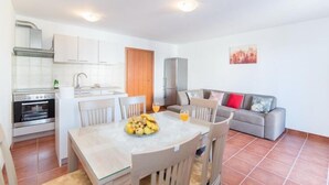 A compact living space with a kitchen, dining area, and a sofa.