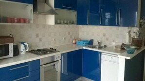 A modern kitchen with blue cabinets, a gas stove, a microwave, and a dishwasher. - Apartment Roksy - Two-Bedroom Apartment with Terrace and Sea View (ST) (Supetar)