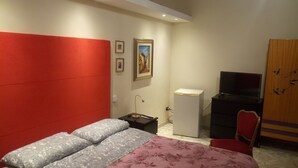 A bedroom with a bed, a desk, a TV, and a wardrobe. - Polvere di Stelle (Altamura)