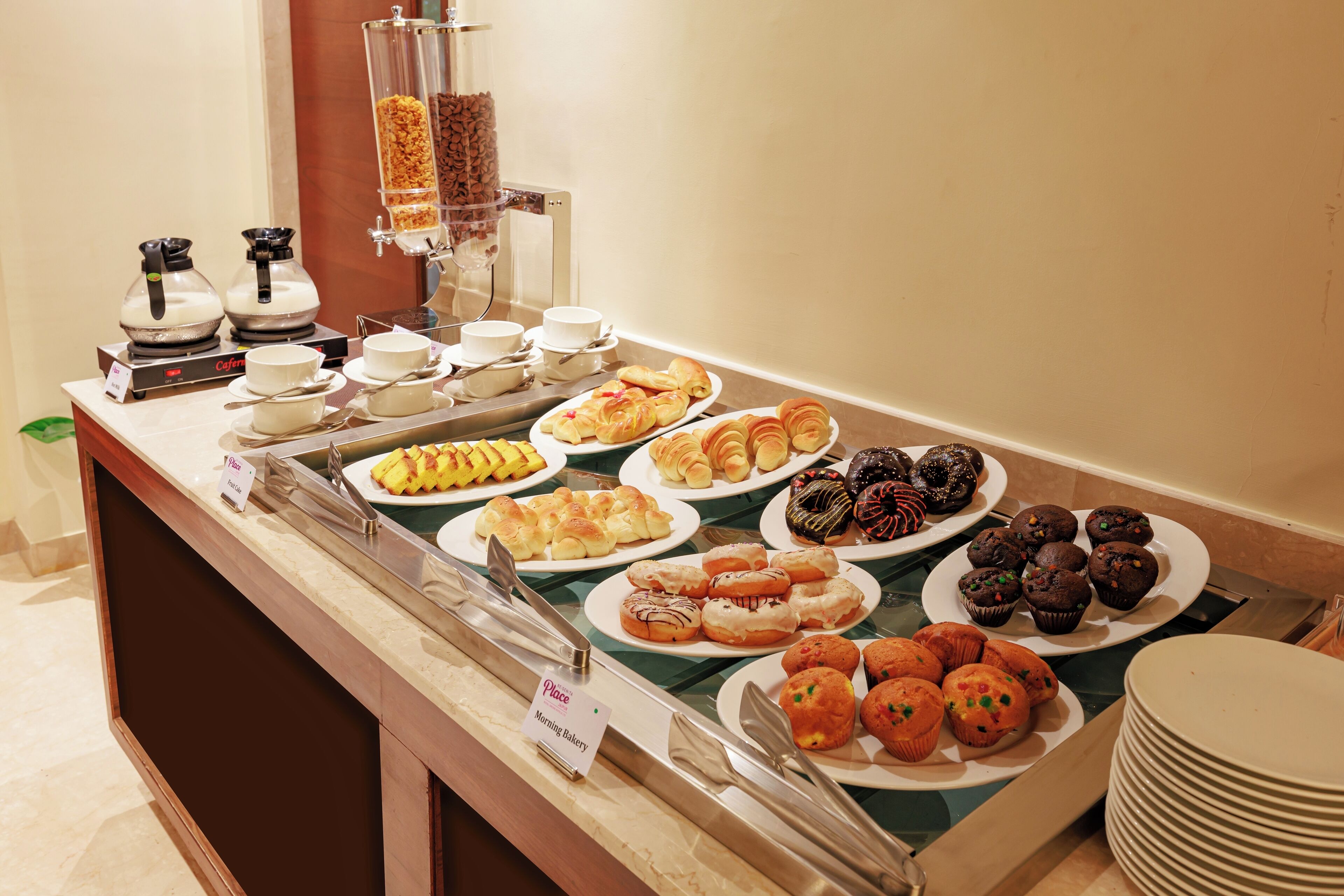 A buffet with various baked goods and a coffee station.