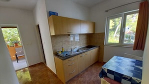 A compact kitchen with a sink, cabinets, and a window.