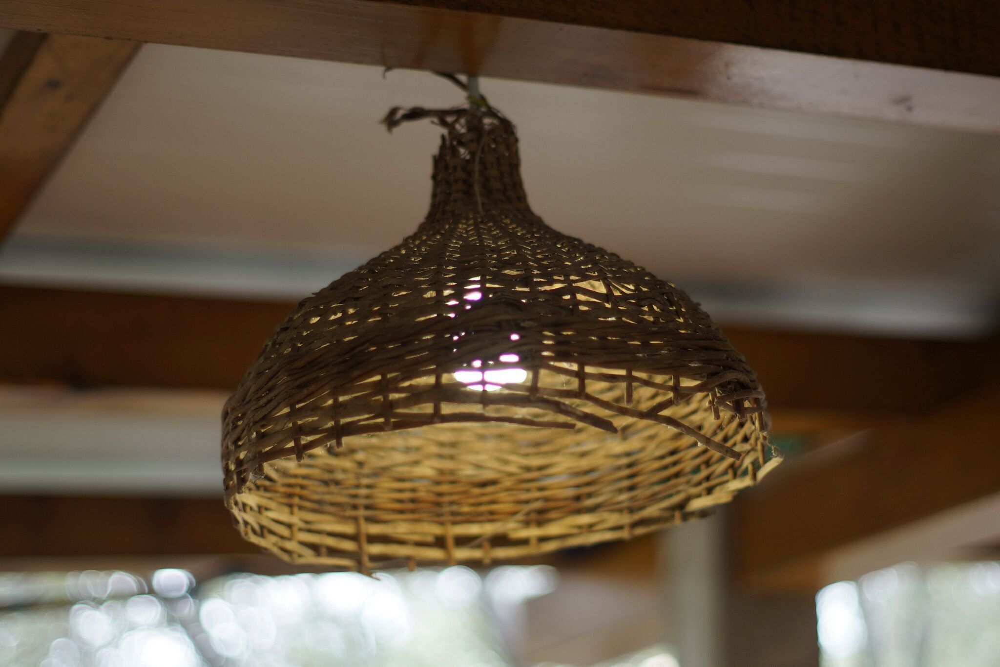 A woven hanging light fixture with a visible structure and a hanging mechanism.