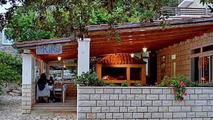 A traditional building with a brick facade, a wooden porch, and a visible fireplace. - Guest House Kiko - Budget Twin Room - No.1 (Pomena)
