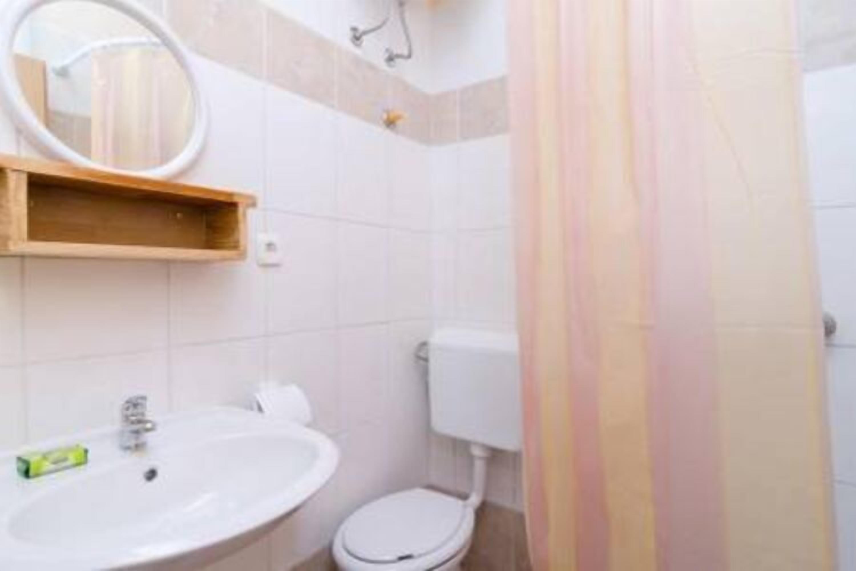 Un baño con lavamanos, inodoro y espejo.