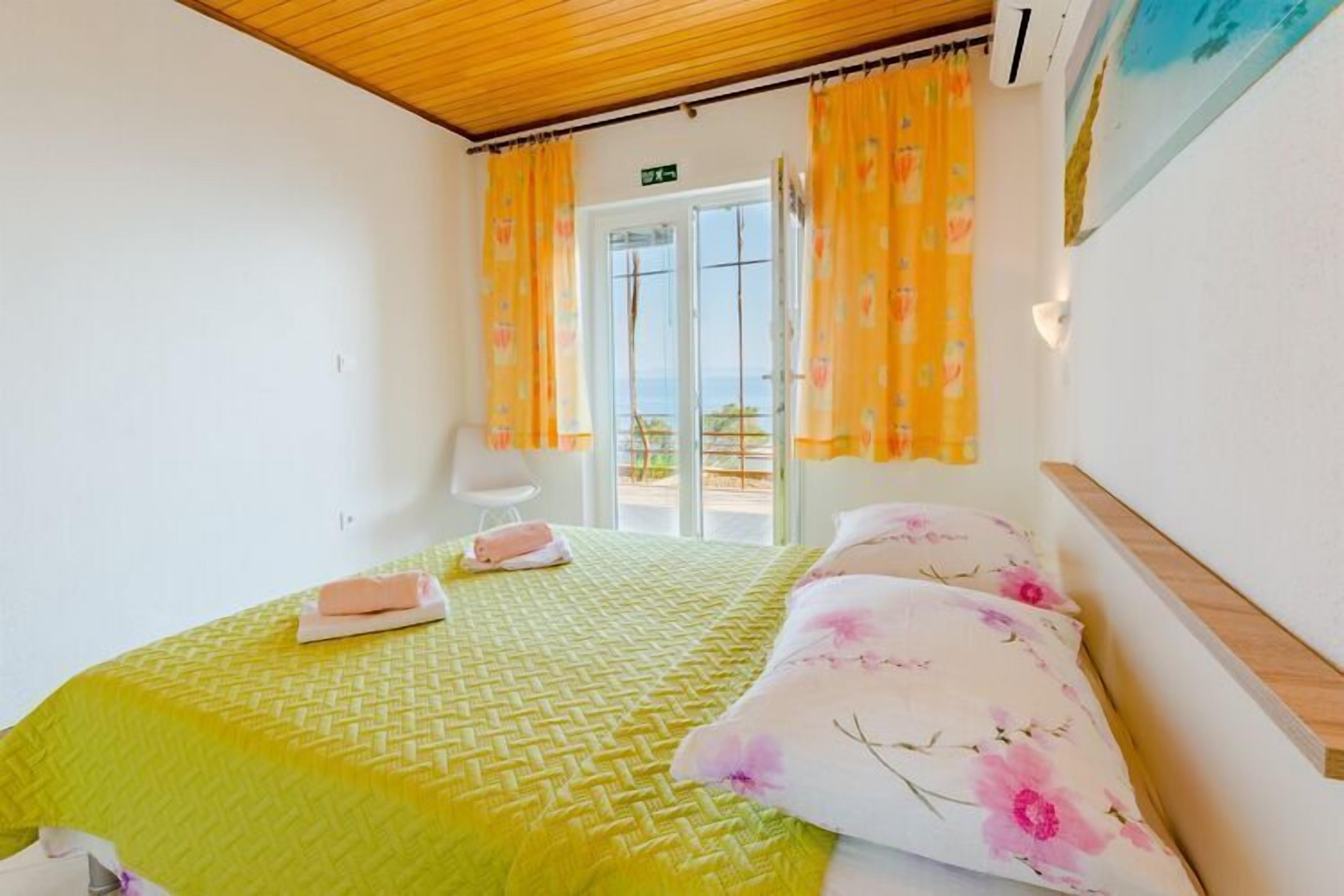 Une chambre à coucher avec un lit, une chaise et une fenêtre avec des rideaux.
