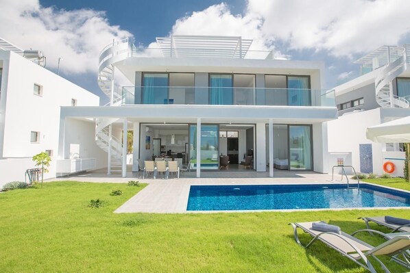 A modern two-story house with a swimming pool, outdoor seating, and a spiral staircase. - Ayia Napa Nissi Pearl Villas (Ayia Napa)