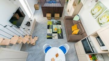 Un salon moderne avec une table centrale, un canapé et un téléviseur.