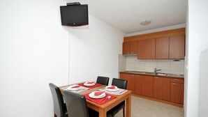 Cocina compacta con armarios de madera y salpicadero de azulejos.