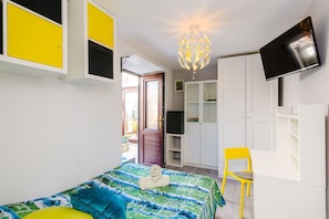 Une chambre à coucher avec un lit, une chaise, une télévision et une armoire.