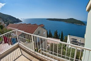 Un balcón con vista al mar y una isla distante.