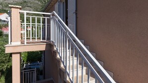 A building with a white staircase and balcony railing.