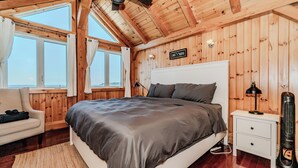Un dormitorio con paneles de madera, una cama, una mesita de noche y una lámpara, con un letrero que dice 'Lake House'.