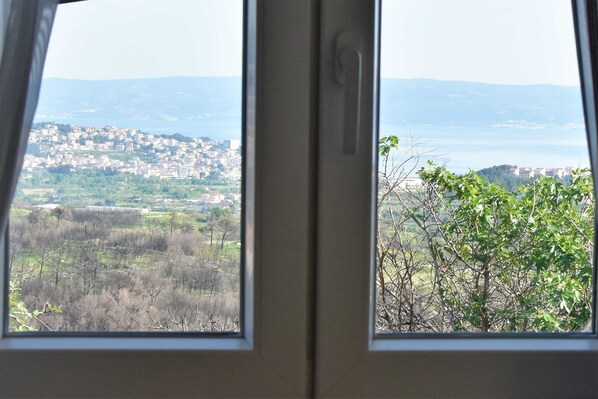 A view through a window of a cityscape with buildings and a body of water in the distance. - Apartment Meryl (ST) - Two Bedroom Apartment with Sea View (Mravince)