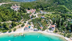 Een kustdorp met huizen, een strand en helder turquoise water.