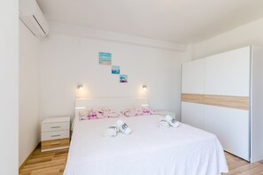 Ein Schlafzimmer mit Bett, Nachttischen, einem Kleiderschrank und Wandbildern.
