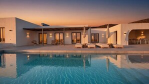 A modern poolside area with a pool, lounge chairs, and a covered seating area. - Faragas Hill Euphoria Villa (Aliki)