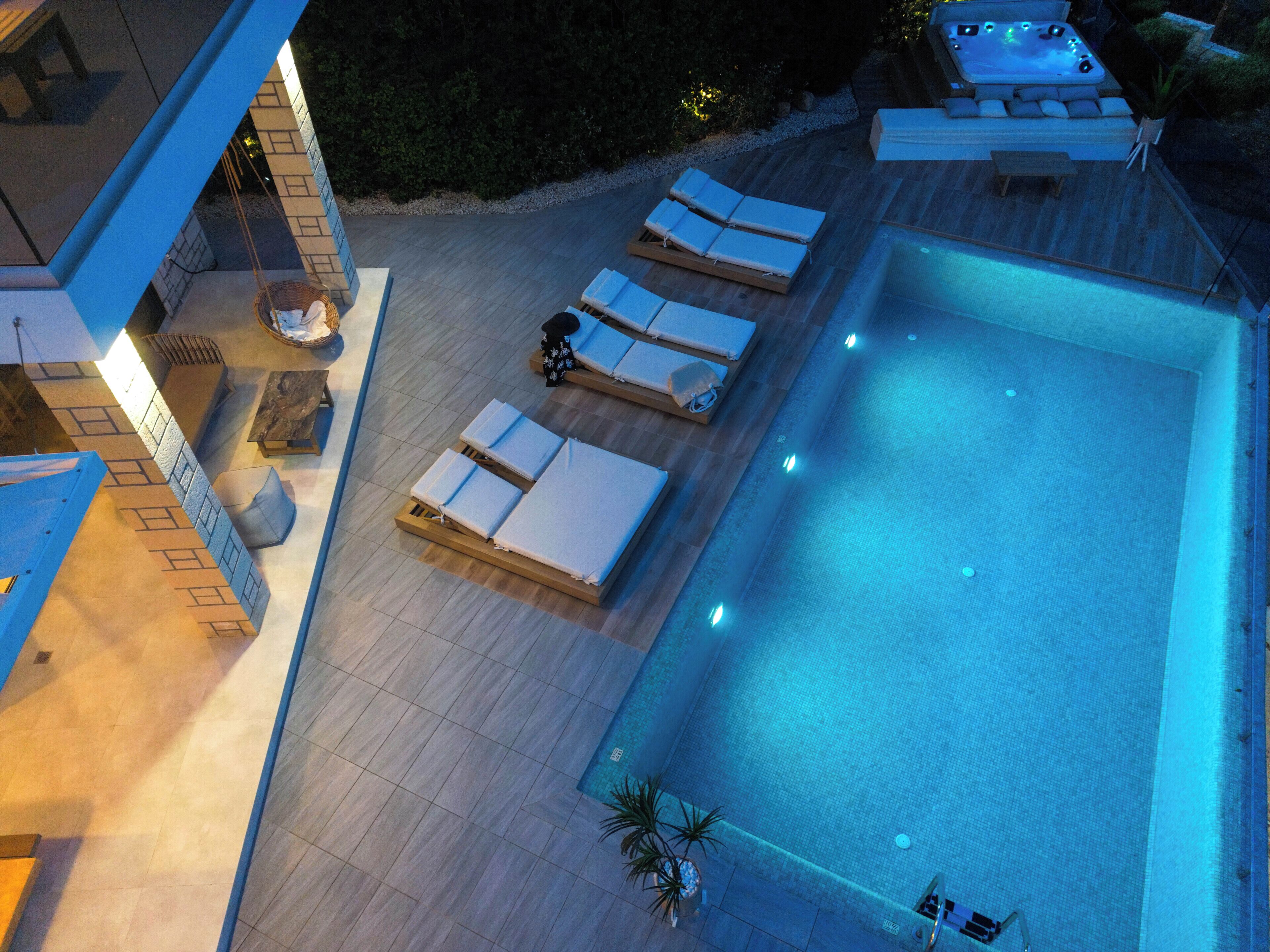Un espace piscine aménagé sur le toit, avec des chaises longues et un jacuzzi.