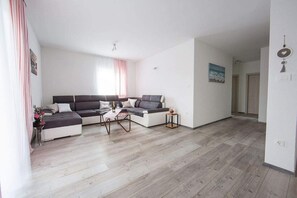 A modern living room with a sectional sofa, a coffee table, and a small side table.