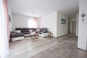 A modern living room with a sectional sofa, a coffee table, and a small side table.