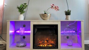 A modern fireplace with a glass front, surrounded by shelves and decorative items. - Glamorous Getaway - Steps to Beach! (Atlantic City)