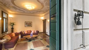 En lobby med et mønstret gulv, to sofaer, et sofabord og en lysekrone.