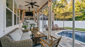 A covered patio with wicker furniture, a ceiling fan, and a pool. - Gone Coastal | Private Pool | 6-Seater Golf Cart | Arcade Games (Watersound)