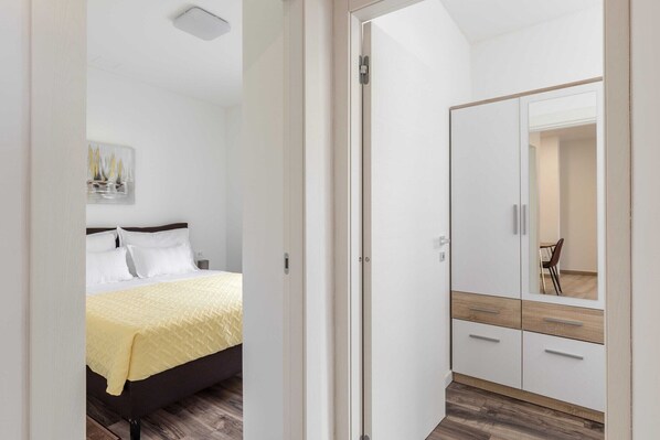 A bedroom with a bed, a bedside table, a wardrobe, and a mirror. - 2 bedroom apartment with balcony (Solin)