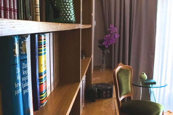 Une bibliothèque remplie de livres, un vase avec des fleurs, une chaise et une table.