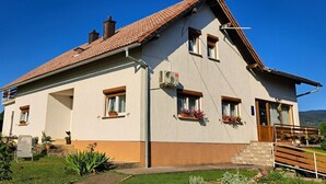 A two-story house with a sloped roof, multiple windows, and a small front porch. - Guesthouse Žafran- Room With Landscape View (Plitvicka Jezera)